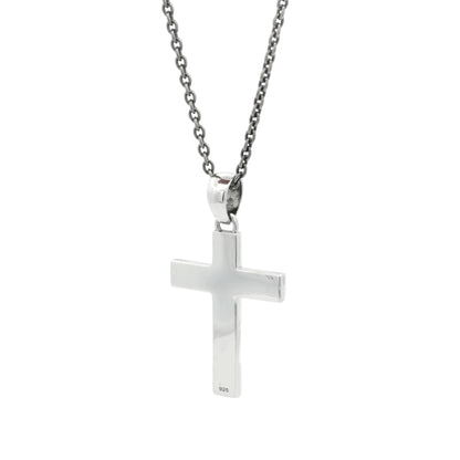Silver cross pendant on a chain against a white background